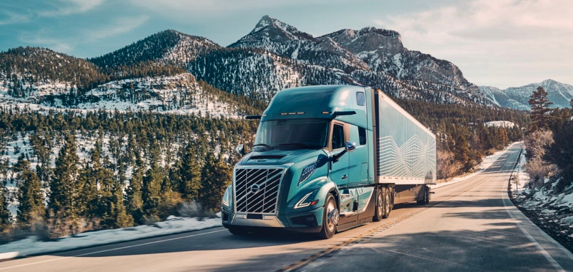 Semi-truck hauling a trailer on a scenic mountain road