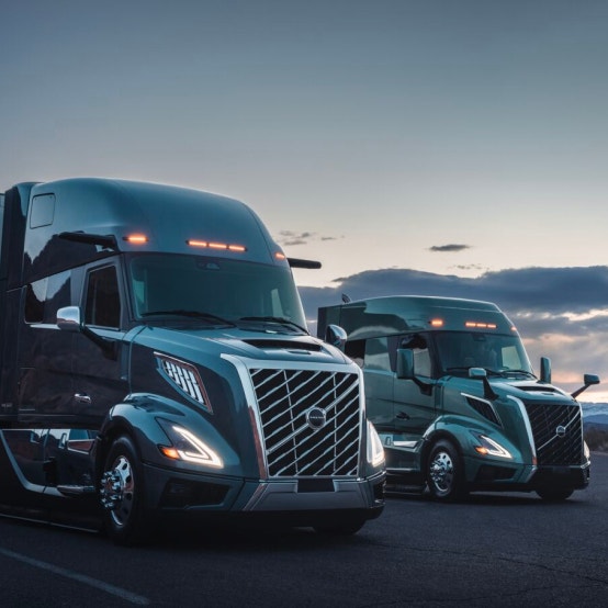 Two trucks parked side by side at dusk with LED lighting
